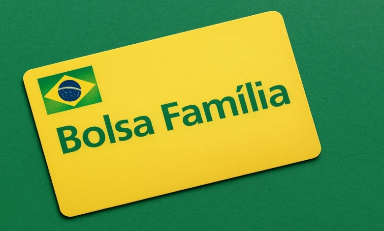 Celular exibindo aplicativo Bolsa Família aberto na tela, com destaque para consulta de aprovação do benefício