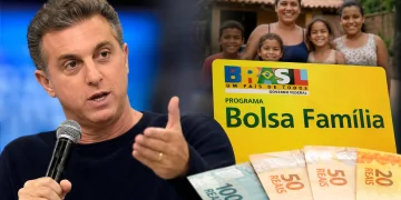 Luciano Huck durante evento ao lado de representação do Bolsa Família e de uma família beneficiária, em imagem que ilustra debate sobre declarações do apresentador e estudos sobre permanência no programa social.